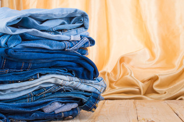 Blue jeans a pile on a wooden table