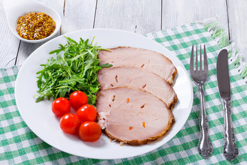 Sliced meat with arugula salad, cherry tomatoes, top view, close
