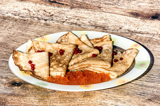 Russian pancakes &ndash; blini with red caviar and currants.