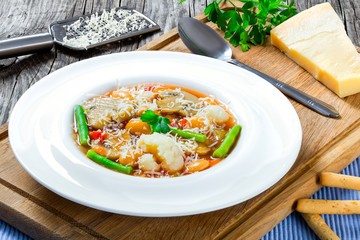 Minestrone vegetable soup with beans, cauliflower, tomatoes, close-up, top view