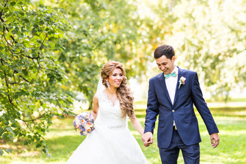 Wedding couple holding hands outdoors