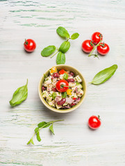 Healthy kidney beans salad with Goat cheese and tomatoes on light rustic background, top view