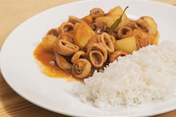 Delicious homemade squid stew with potatoes and white rice.