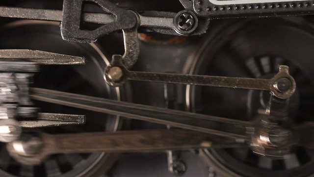Miniature steam locomotive driving wheels and connecting rods start turning then accelerate