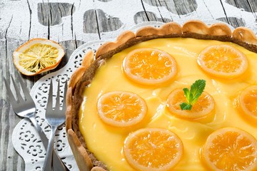 Lemon custard tart, decorated with biscuits, top view, close-up