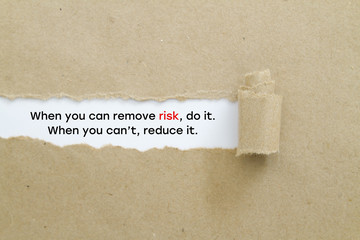 "When you can remove risk, do it. When you can't, reduce it. " slogan written under torn paper. Risk management concept.