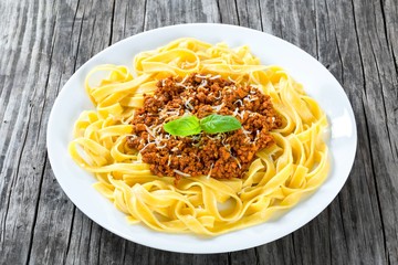 Bolognese ragout with italian pasta on a white plate, close-up