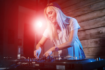 Fototapeta na wymiar Cute dj woman having fun playing music at club party