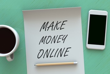 MAKE MONEY ONLINE, message on paper, smart phone and coffee on table