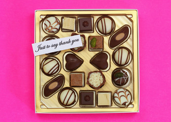 Just to say thank you card with box of assorted chocolates on pink background
