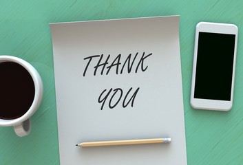 THANK YOU, message on paper, smart phone and coffee on table
