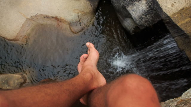 Closeup Man Feet Motion over Small Rocky River