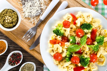 Tortellini with grilled cherry tomatoes, broccoli, red bell pepper, top view
