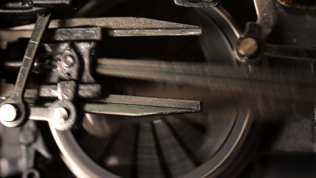 Miniature steam locomotive driving wheels and connecting rods start turning then accelerate