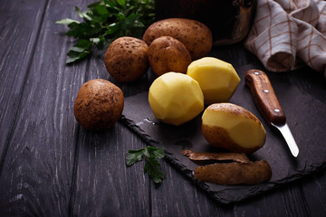 Uncooked peeled potatoes on dark background