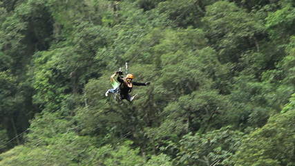 Young couple of tourists enjoying an exhilarating zipline adventure,embracing the thrill and excitement in a captivating way. - Powered by Adobe