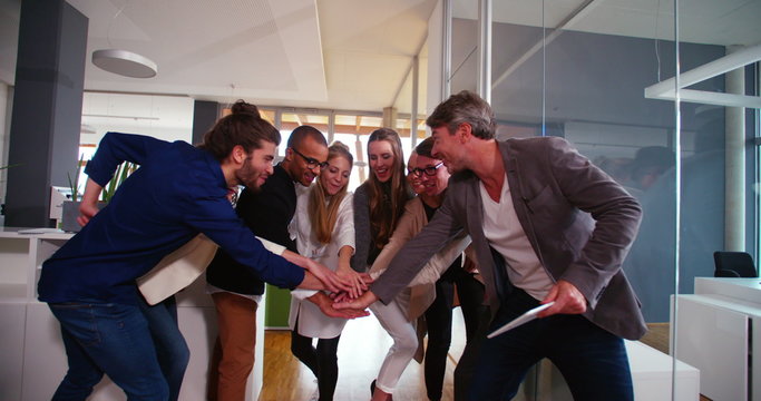 Multi-ethnic group of start up colleagues celebrating in business office