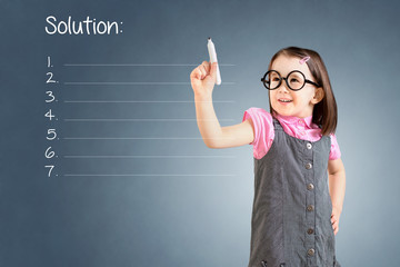 Cute little girl wearing business dress and writing blank solution list. Blue background.