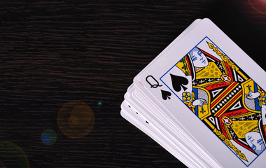 Deck of Playing cards with queen card on wood background
