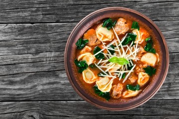 tortellini soup with italian sausages, spinach, tomato, parmesan cheese , top-view