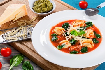 tortellini soup with italian sausages, spinach, tomato, parmesan cheese , pesto-sauce