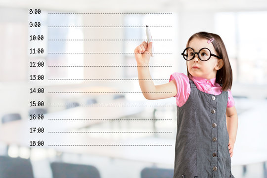 Cute little girl wearing business dress and writing blank appointment schedule. Office background.