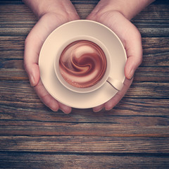hands holding hot cup of coffee