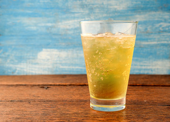 Beer bubbles in glass on wooden floor.