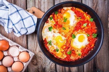 Shakshuka. Fried eggs with tomato, paprika and parsley