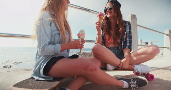 Teen hipster friends enjoying ice cream at the beachfront
