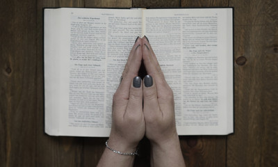 Betende Hände auf einer Bibel