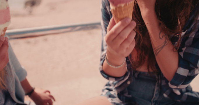 Teen hipster girls  enjoying ice cream at the beachfront