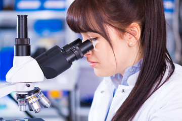 Young technician look at science microscope