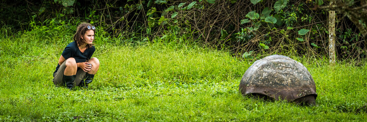 Girl staring intently at Galapagos giant tortoise