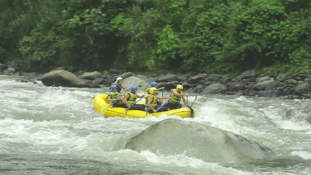 Capture the thrilling adventure of a group of six people whitewater rafting on Ecuador's Pastaza River,as they navigate the rapids,with an external camera equipped with long telephoto lenses.
