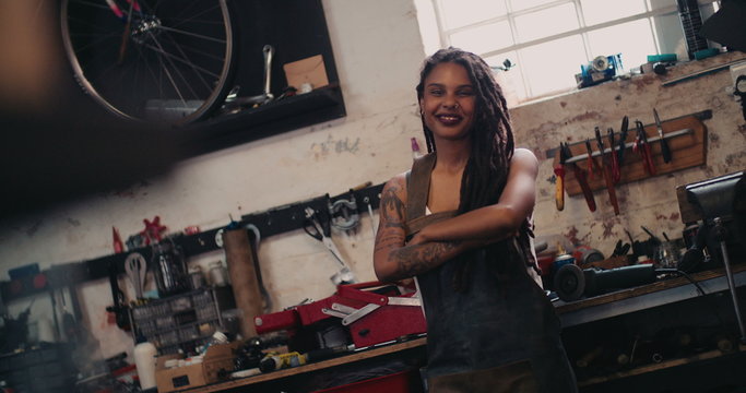 Afro craftswoman standing in her workshop with her tools