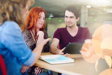 Unposed group of creative business people in an open concept office brainstorming their next project.