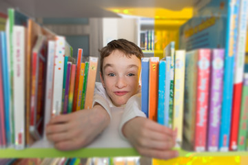 Cute boy reading book in library
