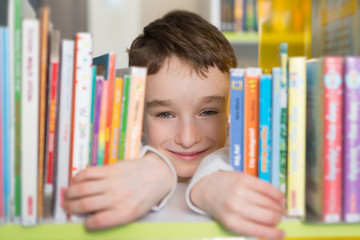 Cute boy reading book in library
