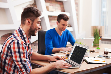 Attractive young workers are using a notebook