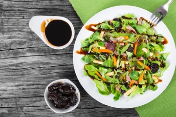 mixed lettuce, spinach, carrot, ham, cheese and prunes salad , top-view
