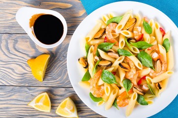 penne pasta salad with shrimps, mussels and baby spinach