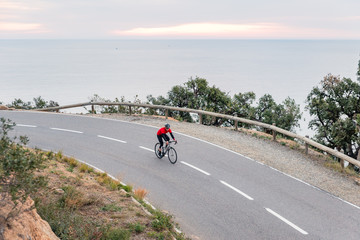 Naklejka premium Early Morning Road Cycling along the Coastal Highway