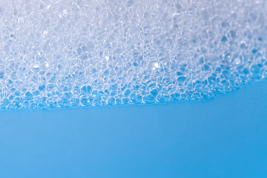 Soap Bath Bubbles Macro View. Laundry Detergent, Suds Textured Pattern. White Soapsuds On Blue Background, Copy Text, Horizontal Photo.