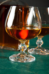 Glass of brandy on a green table top