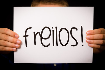 Child holding sign with German word Freilos - See You Later