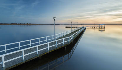 wooden, white pier on the bay at sunset