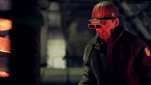 Worker on steel plant operates with  molten metal. HD.