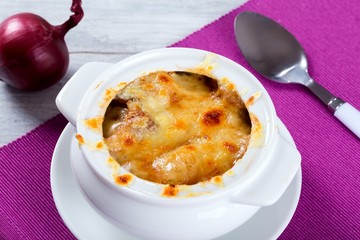 french onion gratin soup in a white pot, close-up