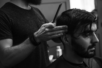 Male barber combing and shaving hair of a male client - 106431379
